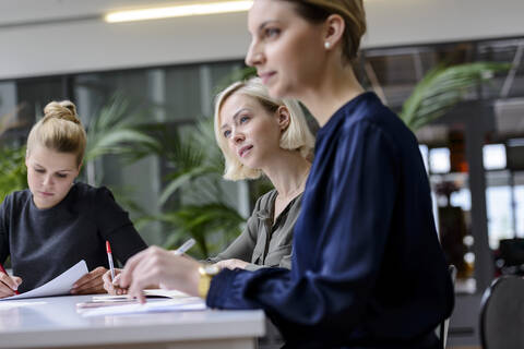 Geschäftsleute, die in einer Sitzung sitzen und konzentriert arbeiten, lizenzfreies Stockfoto