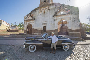 Taxifahrer neben einem alten Cabrio, Trinidad, Kuba - PAF01948