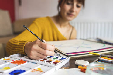 Hand einer Frau, die mit Aquarellfarben malt - WPEF02671