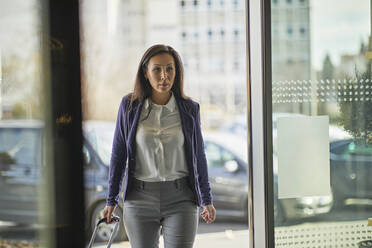 Businesswoman entering hotel - ZEDF02953