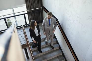 Geschäftsmann und Geschäftsfrau gehen eine Treppe hinunter - ZEDF03065