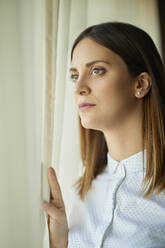 Porträt einer ernsten Geschäftsfrau mit Blick aus dem Fenster - ZEDF03137