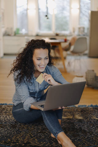 Frau, die eine Online-Zahlung mit Kreditkarte vornimmt, mit Laptop, lizenzfreies Stockfoto