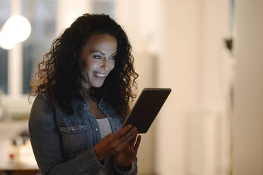 Laughing woman holding digital tablet - JOSEF00049