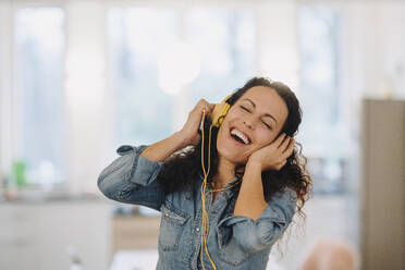 Glückliche Frau, die Musik hört, singt und tanzt, mit Smartphone und Kopfhörern - JOSEF00087