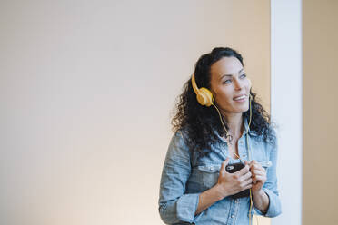 Frau hört Musik, trägt Kopfhörer, benutzt Smartphone - JOSEF00088