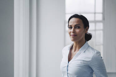 Successful businesswoman, standing by window, potrait - JOSEF00099