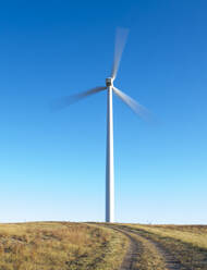 Wind Turbine in motion against blue sky - CAVF75612