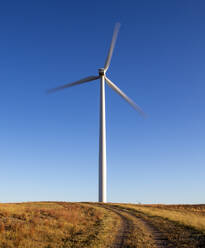 Wind Turbine in motion against blue sky - CAVF75613