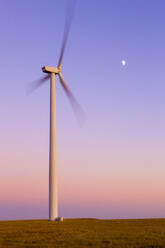 Windturbine in Bewegung gegen blauen Himmel mit Mond - CAVF75626