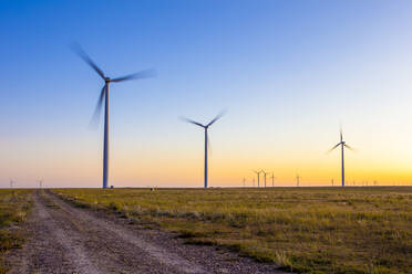 Windturbinen im Feld gegen blauen Himmel und Sonnenuntergang - CAVF75627