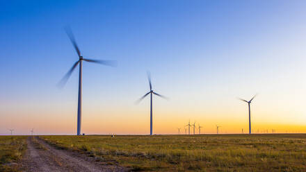 Windturbinen im Feld gegen blauen Himmel und Sonnenuntergang - CAVF75628