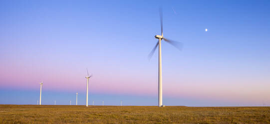 Windturbinen im Feld gegen blauen Himmel in der Abenddämmerung - CAVF75632