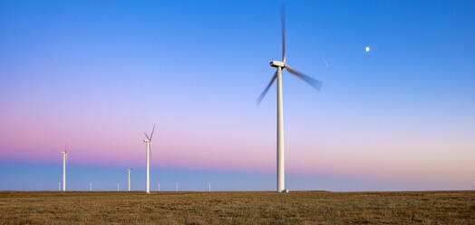 Windturbinen im Feld gegen blauen Himmel in der Abenddämmerung - CAVF75636