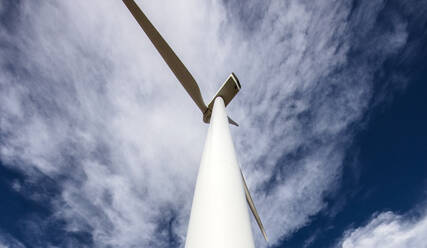 Wind Turbine low angle against cloudy blue sky - CAVF75672