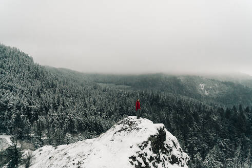 Eine junge Frau steht auf dem Gipfel eines verschneiten Berges in der Columbia-Schlucht - CAVF75675