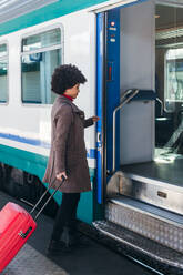 Touristin, die mit dem Zug in den Urlaub fährt - CAVF75680