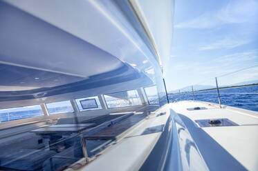Blick vom Deck des Salons an Bord eines Kreuzfahrt-Katamarans durch einen Bea - CAVF75727