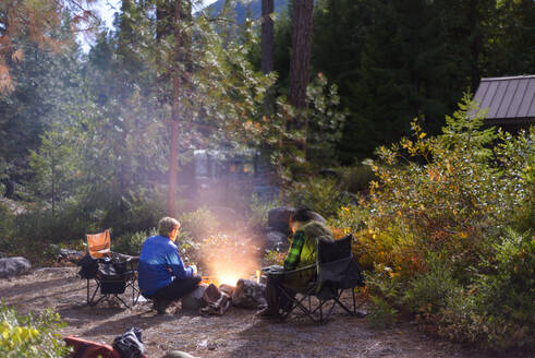 Sitzen um das Lagerfeuer auf einem Campingplatz - CAVF75798