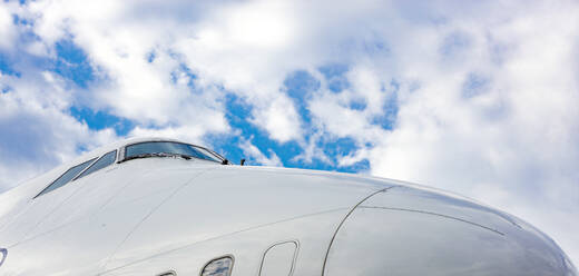 Cockpit eines Düsenflugzeugs vor blauem, bewölktem Himmel - CAVF75817