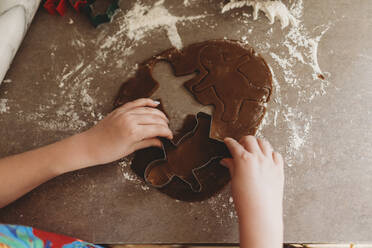 Nahaufnahme von Kinderhänden bei der Herstellung von Lebkuchenmännchen - CAVF75831