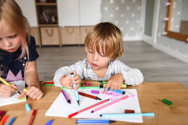 Kleiner Junge mit Schwester beim Zeichnen mit Filzstiften - CAVF75856