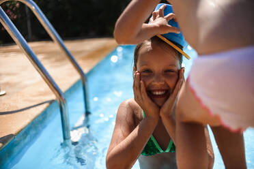 Zwei Schwestern beim Schwimmen im Pool, Blick auf den Rahmen - CAVF75870