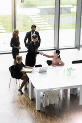 Geschäftsleute schütteln sich die Hände in einem modernen Bürokonferenzraum - BMOF00284