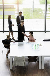 Geschäftsleute schütteln sich die Hände in einem modernen Bürokonferenzraum - BMOF00287
