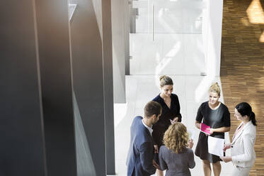 Business people standing in modern office building discussing project - BMOF00292