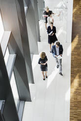 Geschäftsleute gehen in einem modernen Bürogebäude - BMOF00296