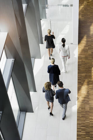 Geschäftsleute gehen in einem modernen Bürogebäude, lizenzfreies Stockfoto