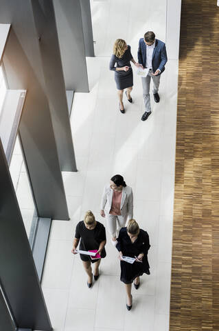 Geschäftsleute gehen in einem modernen Bürogebäude, lizenzfreies Stockfoto