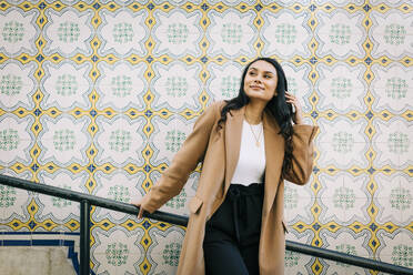 Portrait of fashionable young woman posing in front of Azulejo wall, Lisbon, Portugal - DCRF00011