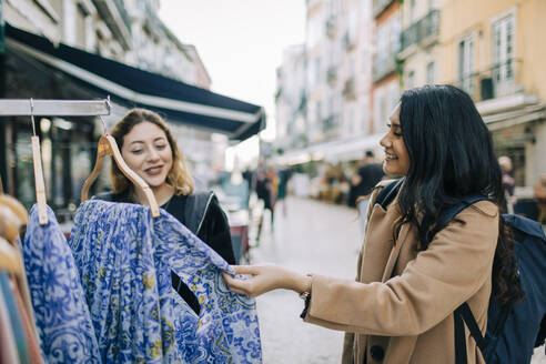 Zwei junge Frauen beim gemeinsamen Einkaufen in der Stadt, Lissabon, Portugal - DCRF00020