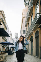 Portrait of smiling young woman in the city, Lisbon, Portugal - DCRF00026