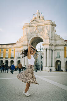Glückliche junge Frau beim Tanzen in der Stadt, Lissabon, Portugal - DCRF00035
