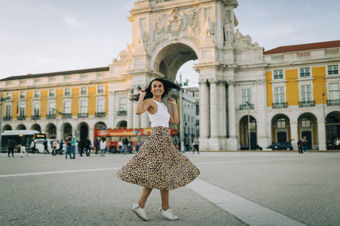 Glückliche junge Frau beim Tanzen in der Stadt, Lissabon, Portugal - DCRF00037