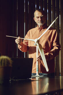 Senior engineer working on wind energy solutions, looking at wind turbine - MCF00557