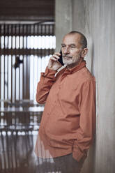 Creative businessman talking on the phone in his minimalistic office - MCF00570