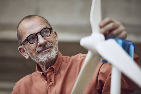 Senior engineer working on wind energy solutions, looking at wind turbine - MCF00571