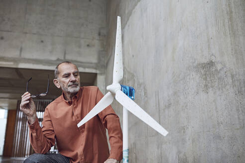 Leitender Ingenieur, der an Windenergielösungen arbeitet, mit Blick auf die Windkraftanlage - MCF00572