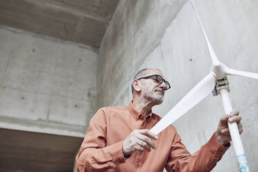 Senior engineer working on wind energy solutions, looking at wind turbine - MCF00574