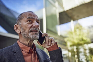 Senior businessman in the city, talking on the phone - MCF00581