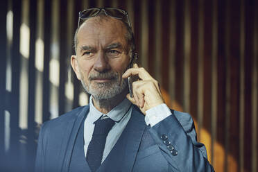 Senior businessman standing in his sustainable office - MCF00627