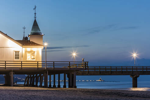 Deutschland, Mecklenburg-Vorpommern, Heringsdorf, Beleuchtete Seebrücke und Seebad in der Abenddämmerung - WDF05848