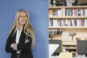 Smiling young businesswoman in loft office - GUSF03376