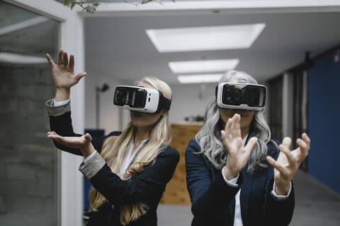 Reife und junge Geschäftsfrau mit VR-Brille, lizenzfreies Stockfoto