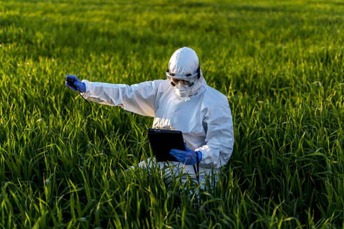 Female scientist researching in field and using measuring device - ERRF02768