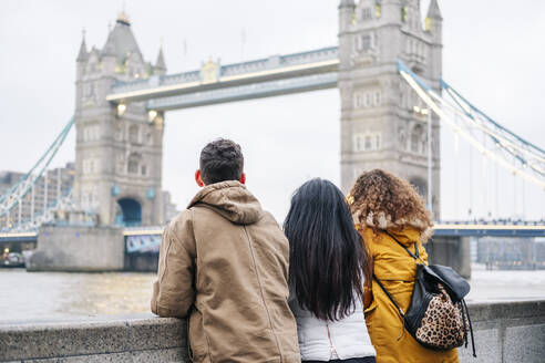London, Vereinigtes Königreich, Gruppe von Freunden mit Blick auf die Tower Bridge - DGOF00505